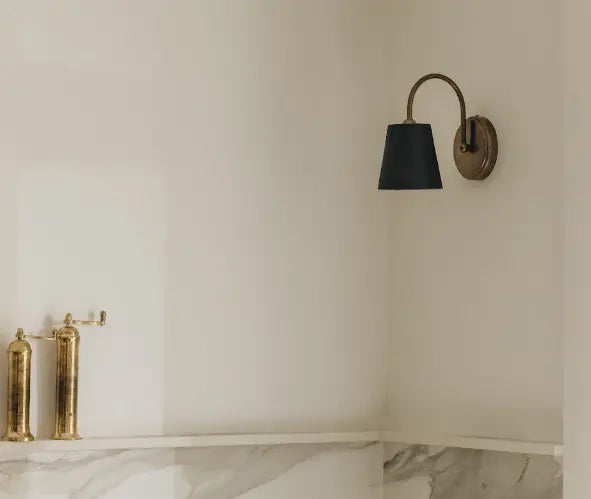 Applique murale en laiton avec abat-jour noir dans une salle de bain en marbre