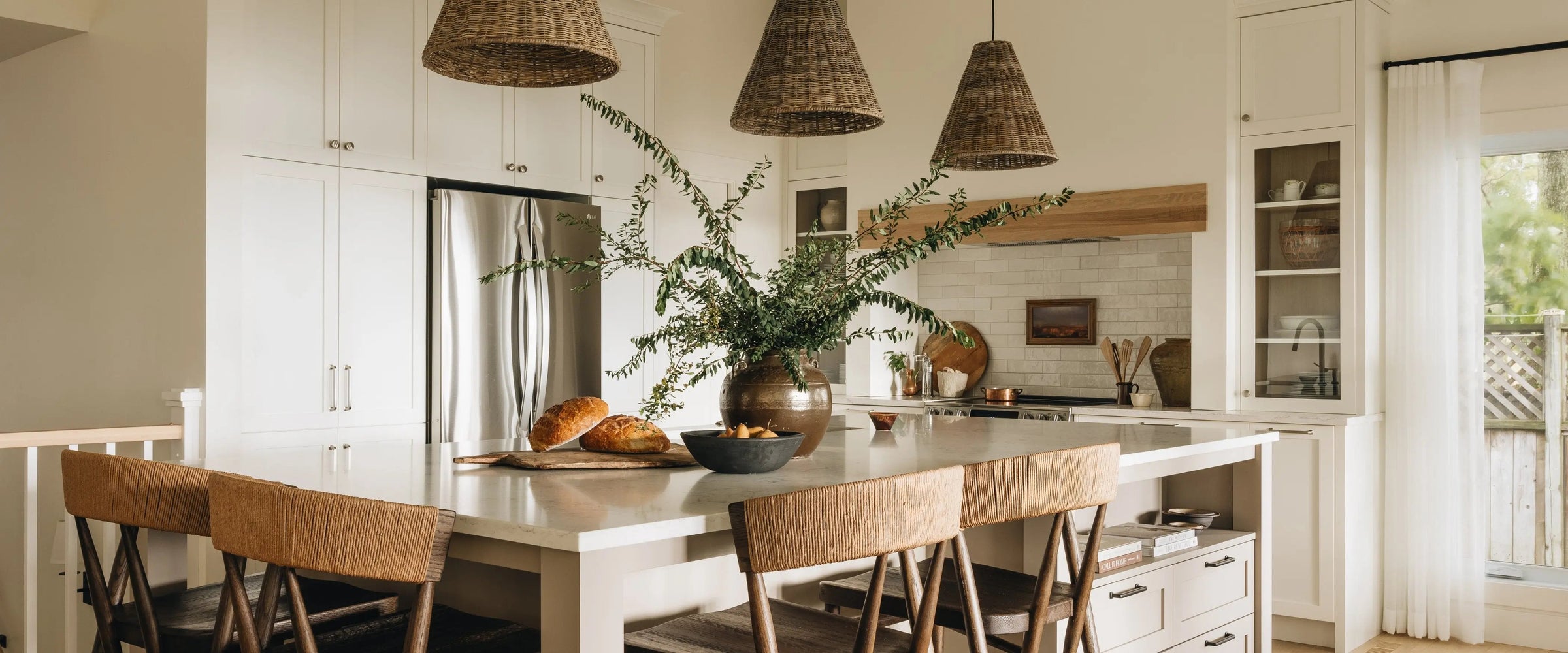Bright kitchen with an island, tabletop accessories and woven pendant lights