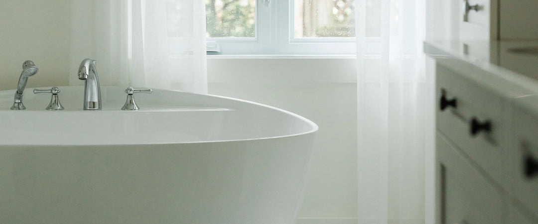 Salle de bain lumineuse avec baignoire et décoration épurée — Maison Olive design