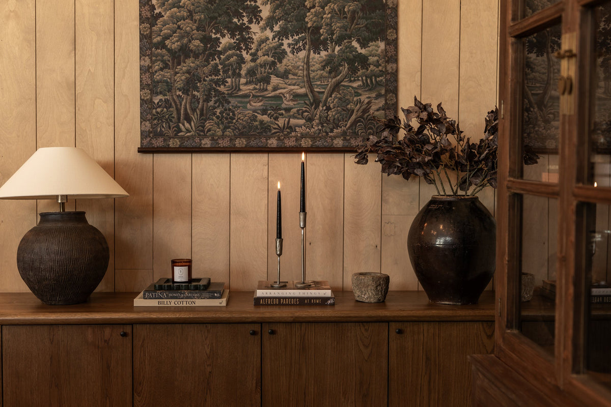 Buffet en bois, lampe, chandelles et vase de branches séchées – Maison Olive