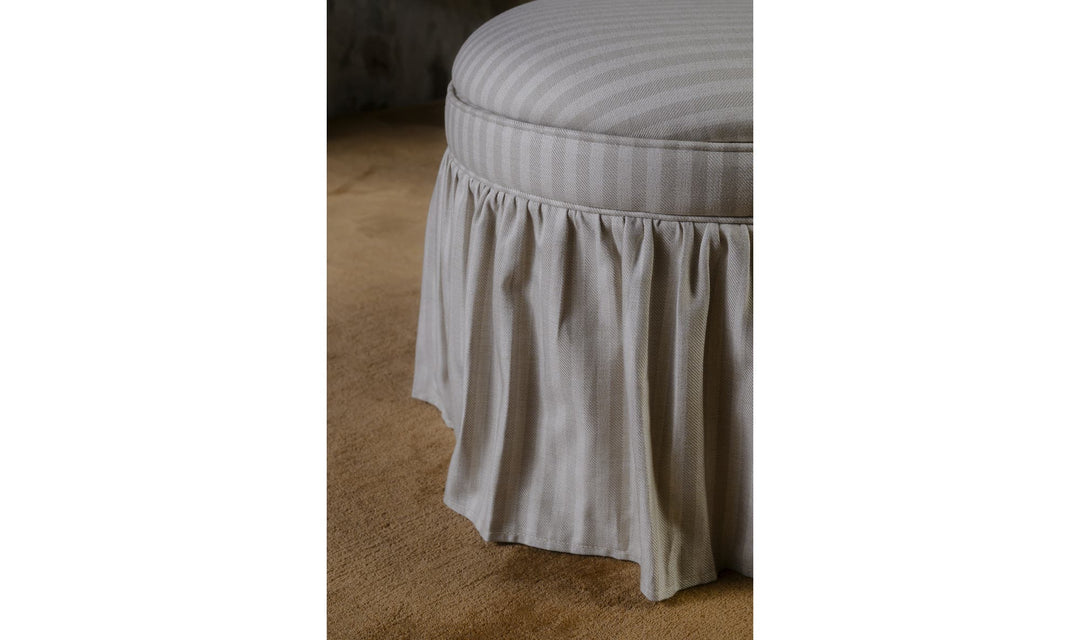 Ottoman de rangement HEIDI rayures beige, détail de la jupe froncée dans un salon