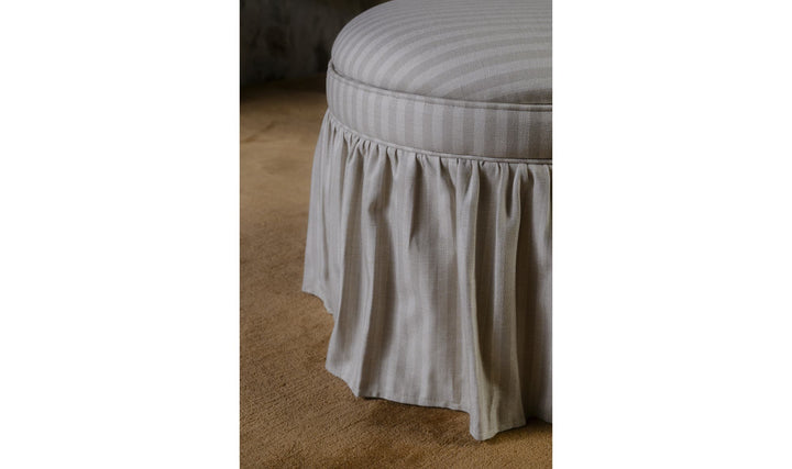 Ottoman de rangement HEIDI rayures beige, détail de la jupe froncée dans un salon