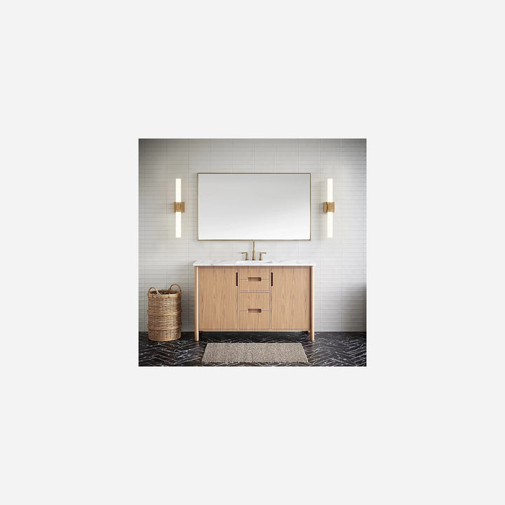 Applique murale Maison Olive LED tubulaire dorée installée de chaque côté d'un miroir de salle de bain moderne