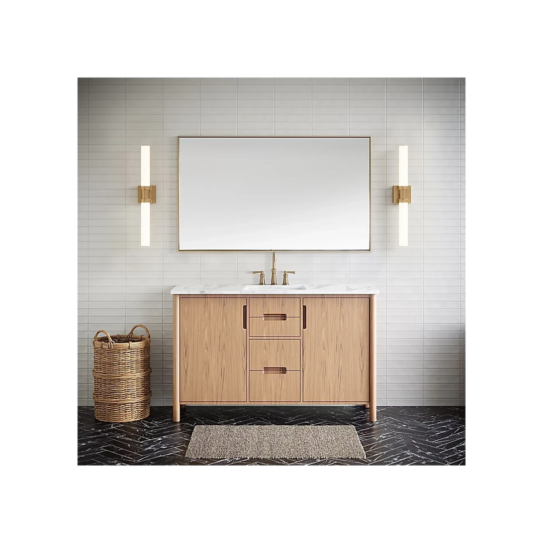 Applique murale Maison Olive LED tubulaire dorée installée de chaque côté d'un miroir de salle de bain moderne