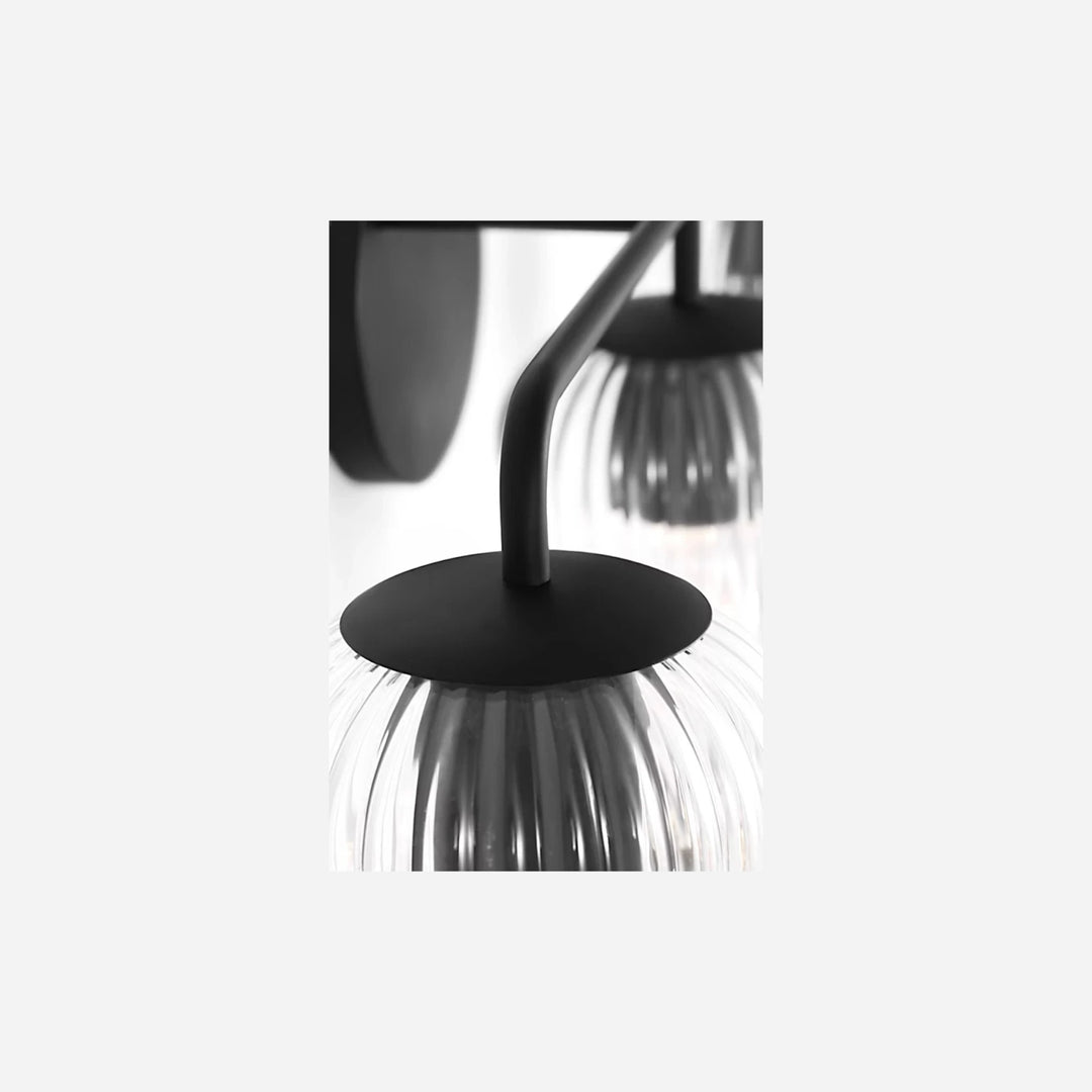 Applique murale triple Maison Olive Eisele avec abat-jours en verre strié et structure noire élégante