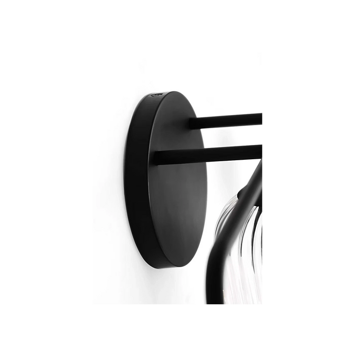 Applique murale Maison Olive en métal noir avec abat-jour cylindrique en verre strié transparent.