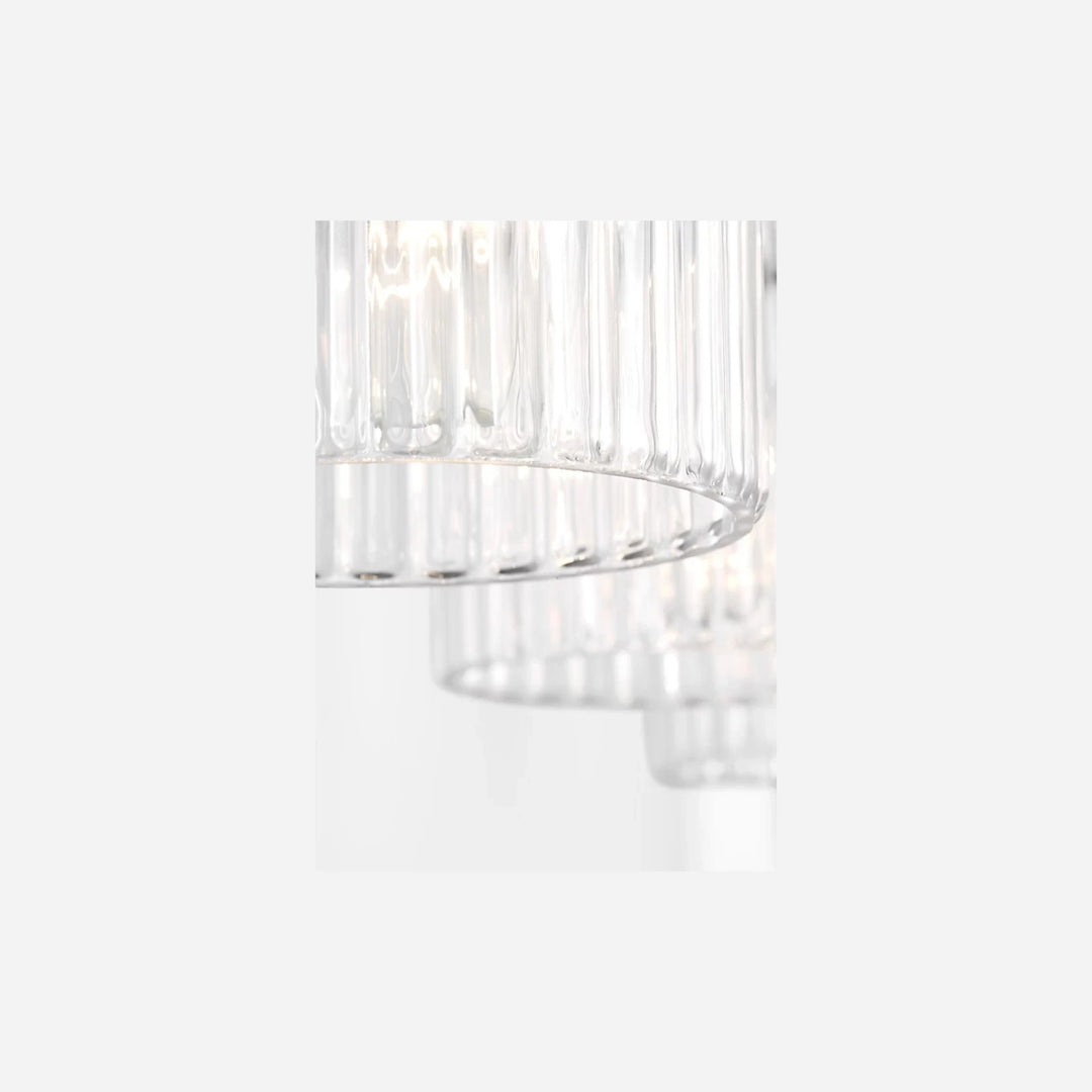 Gros plan sur les abat-jours cylindriques en verre strié transparent de l'applique murale triple Eisele Maison Olive