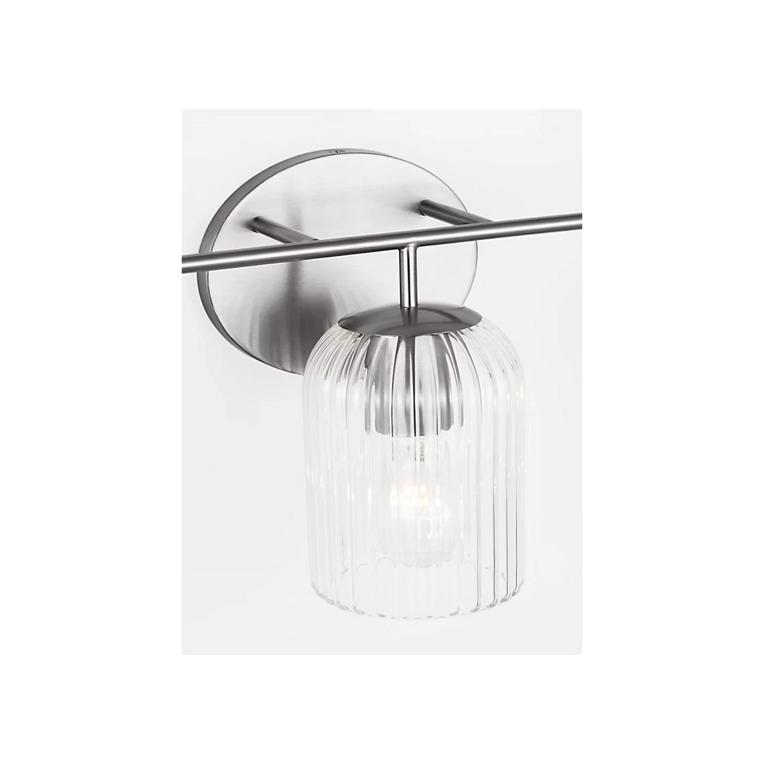Applique murale Maison Olive en laiton brossé avec abat-jour cylindrique en verre strié transparent.