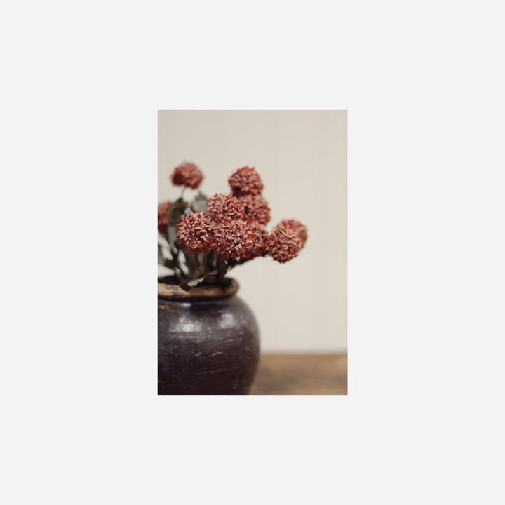 Bouquet de fleurs artificielles Maison Olive Morandi Bloom mauve dans un vase en céramique sombre