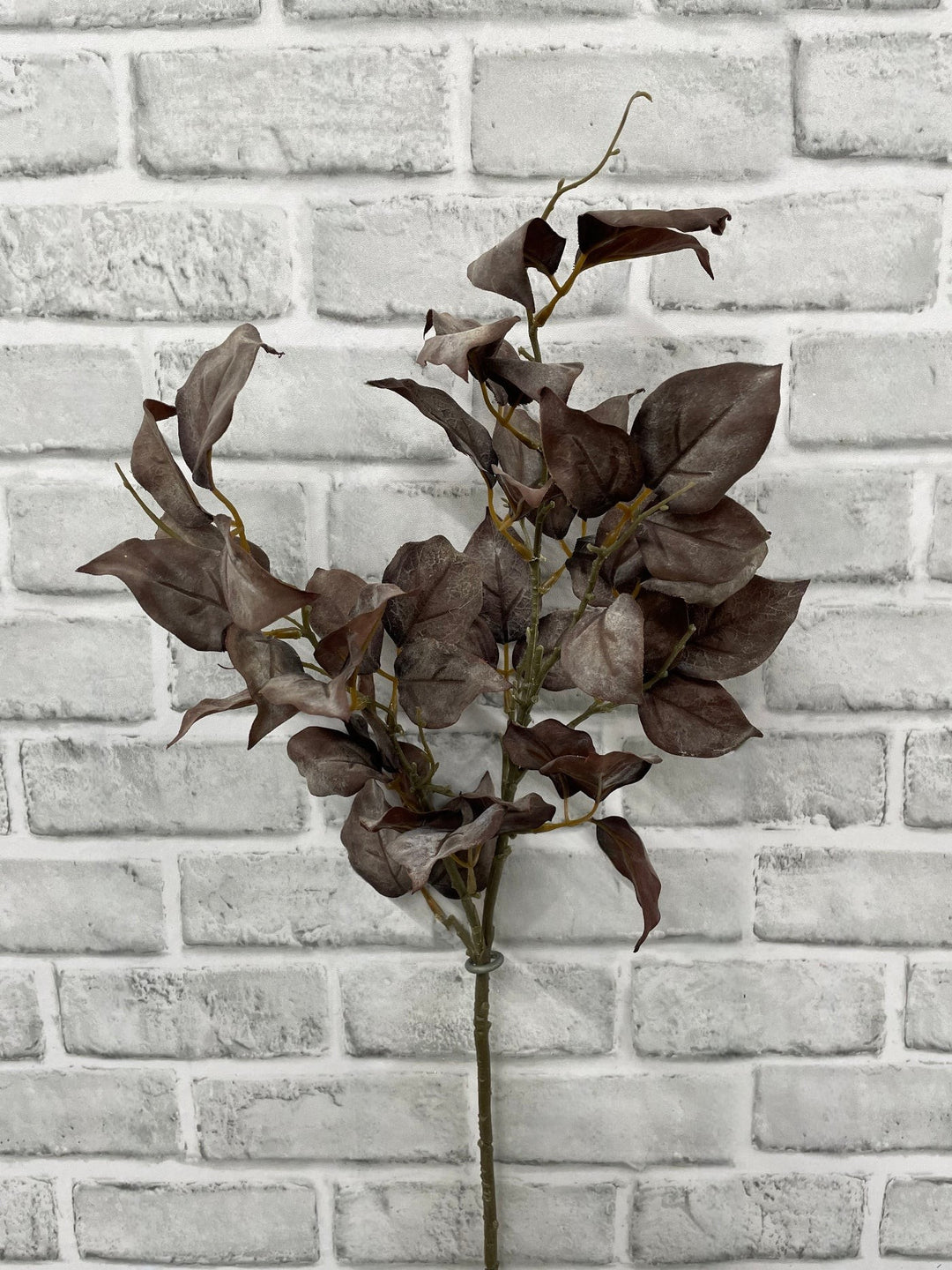 Branche artificielle Maison Olive aux feuilles brun profond pour une décoration intérieure élégante et automnale.