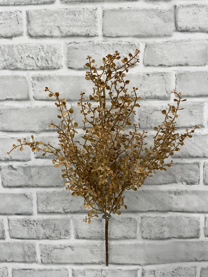 Branche décorative artificielle Maison Olive aux feuilles dorées automnales sur fond de mur en briques grises