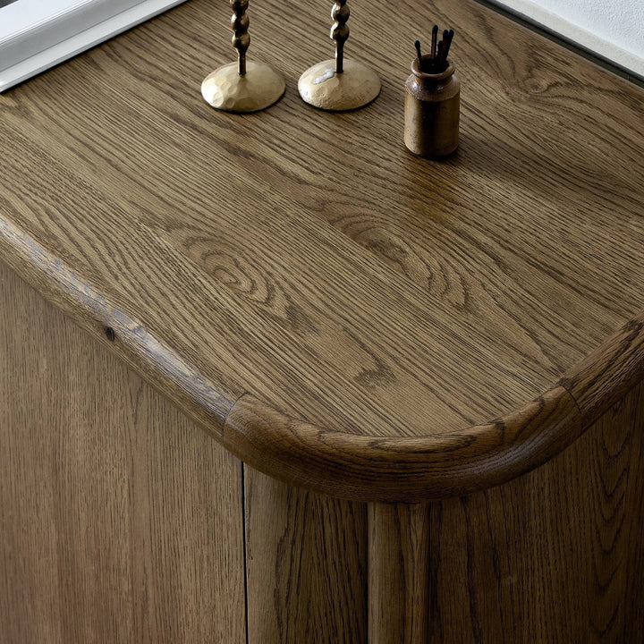 Buffet FLORENT en chêne de Maison Olive avec un grand cadre cylindrique et des lignes courbes douces. Finition chaleureuse.