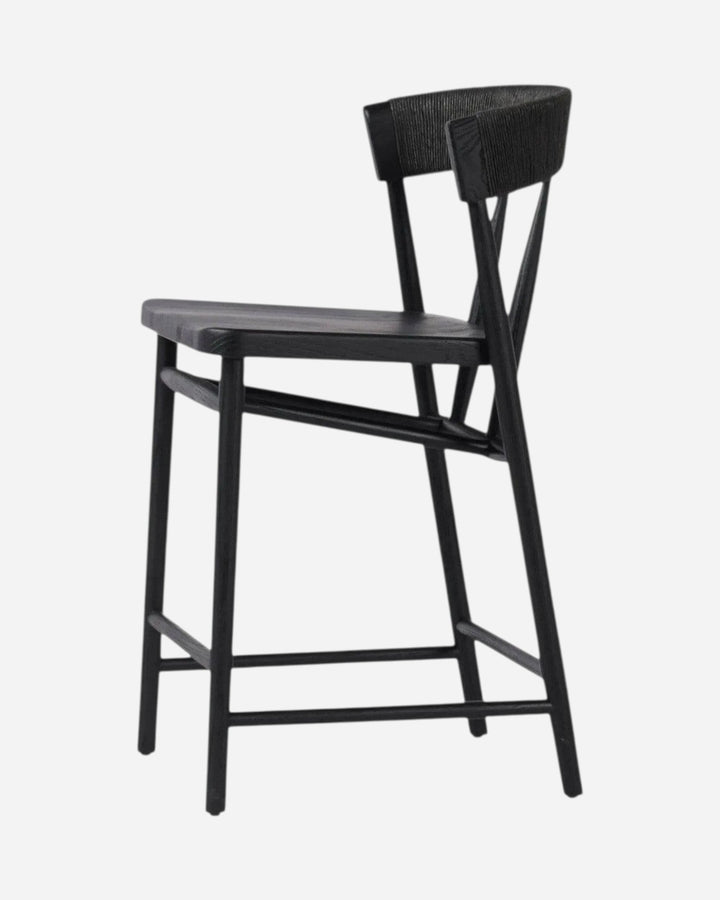 Tabouret de comptoir Maison Olive Buxton en chêne massif noir avec dossier en jonc de papier, vue de profil.