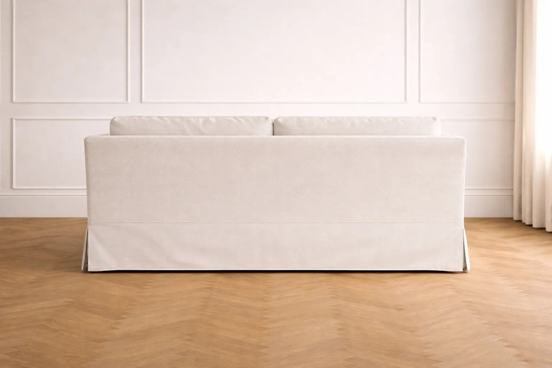 Canapé William de Maison Olive en tissu beige clair avec housse élégante, vue arrière dans un salon lumineux.