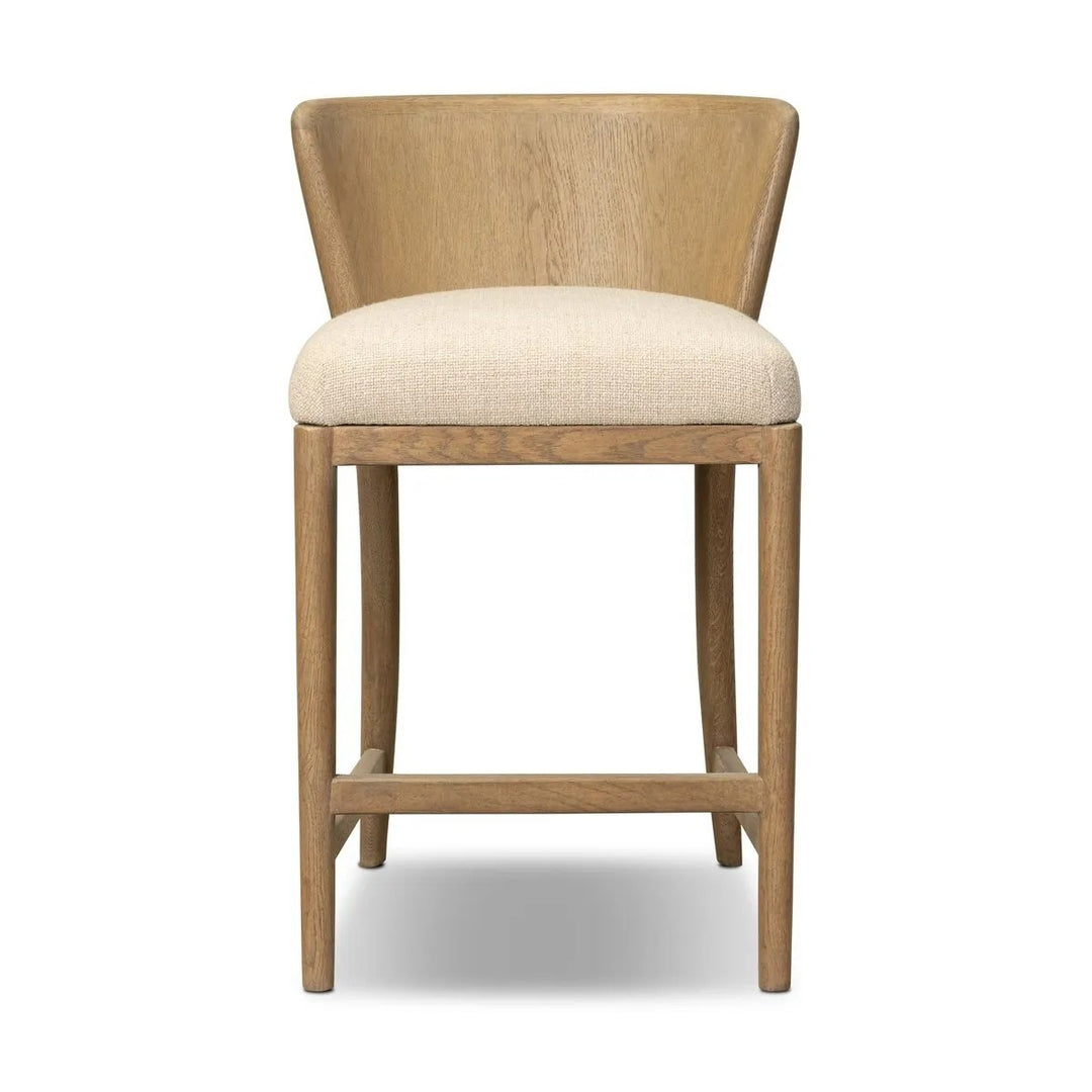 Maison Olive chaise en bois clair avec assise rembourrée en tissu crème texturé. Design épuré et naturel.
