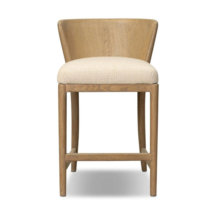 Maison Olive chaise en bois clair avec assise rembourrée en tissu crème texturé. Design épuré et naturel.
