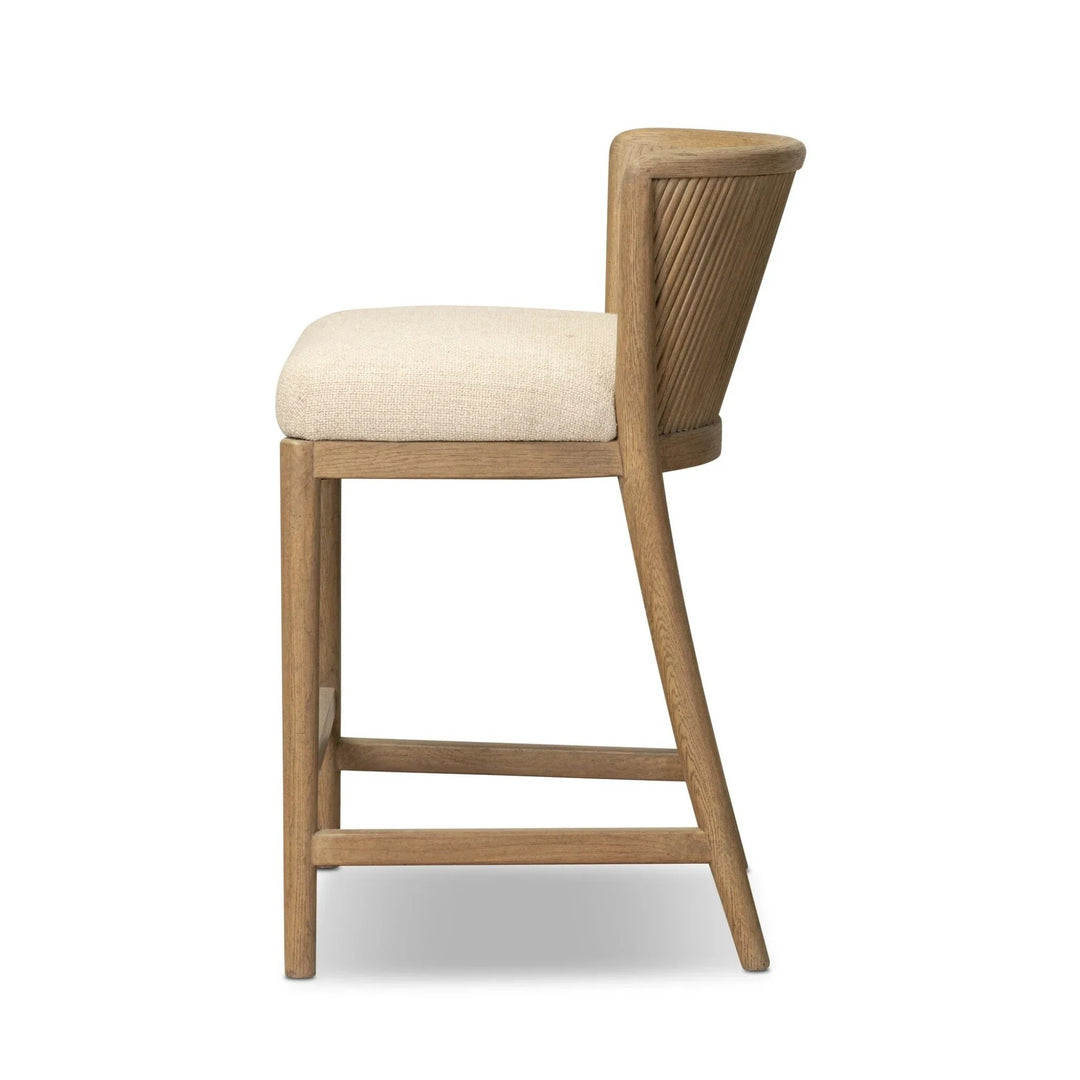 Maison Olive Chaise en bois clair avec assise rembourrée en tissu crème texturé, dossier incurvé avec cannelures verticales.