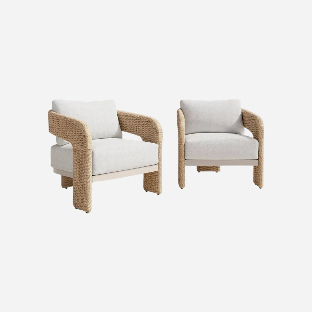 Deux chaises d'extérieur Maison Olive Rolos avec osier naturel, cadre en aluminium et coussins en tissu bouclé blanc.