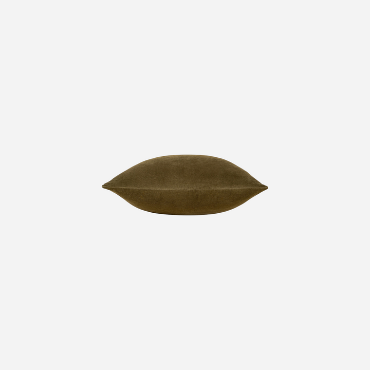Coussin décoratif Maison Olive en velours vert olive doux et soyeux sur fond beige clair