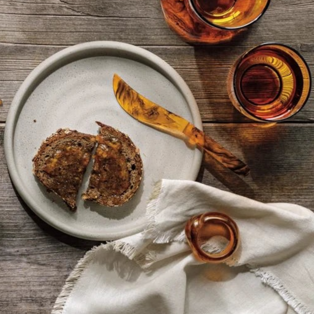 Ensemble de couteaux à tartiner Maison Olive en résine effet ambre sur une table en bois rustique avec du pain