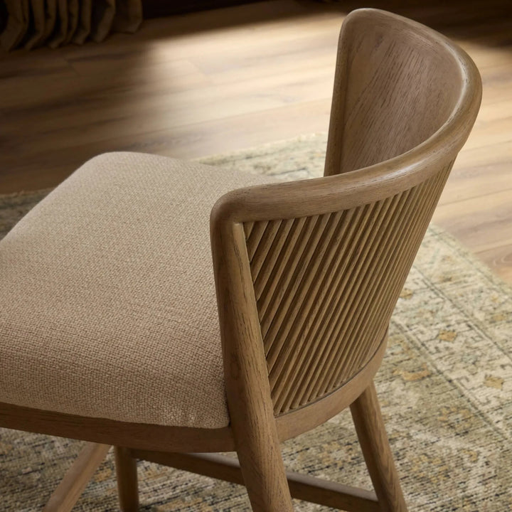 Maison Olive fauteuil en bois clair avec assise en tissu crème texturé et dossier cannelé. Design épuré et naturel.