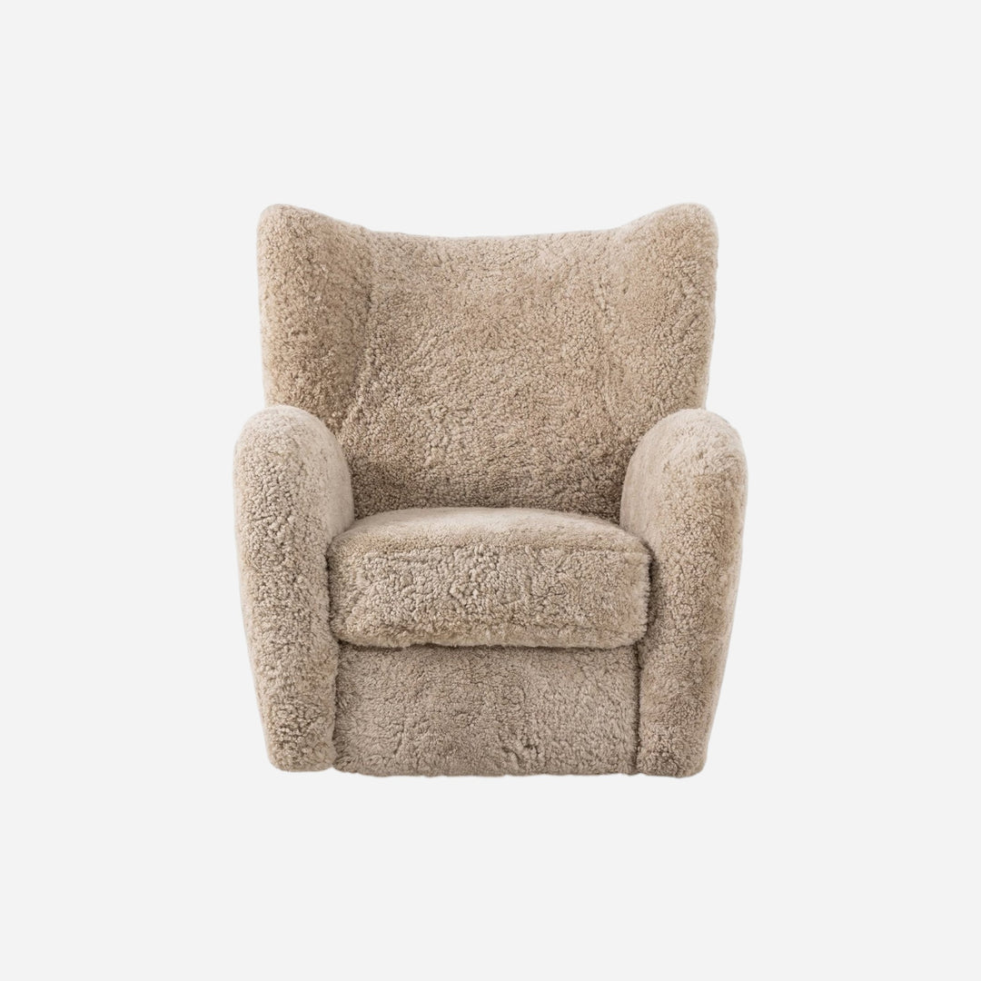 Fauteuil pivotant Maison Olive en laine bouclée couleur sable, design enveloppant et confortable.