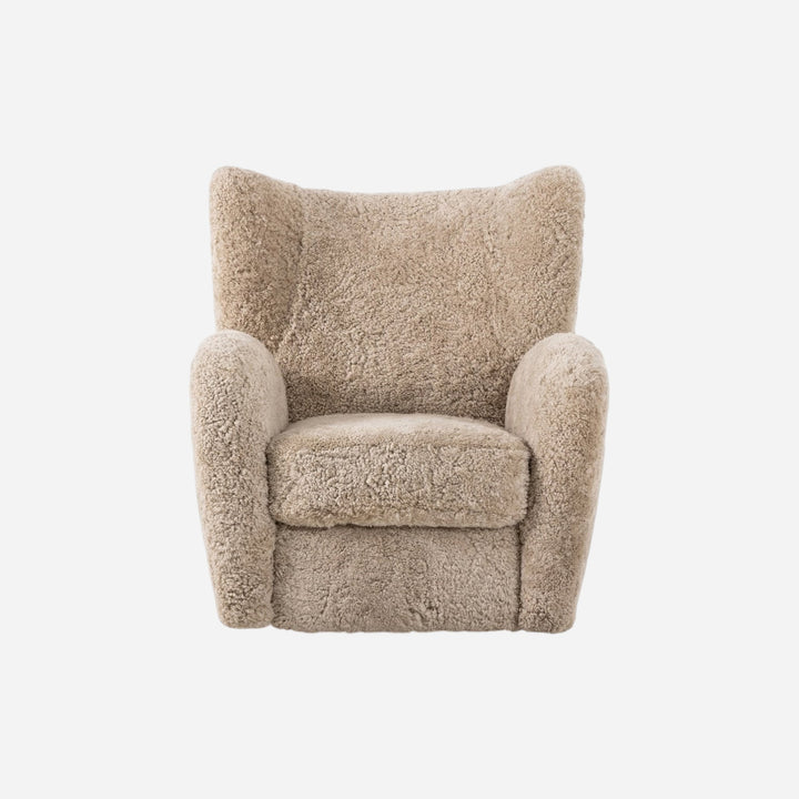 Fauteuil pivotant Maison Olive en laine bouclée couleur sable, design enveloppant et confortable.