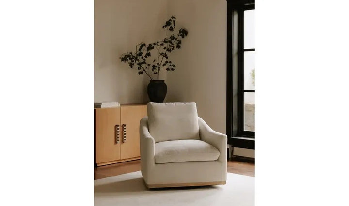 Fauteuil pivotant Maison Olive en tissu taupe texturé avec base en bois clair dans un salon contemporain épuré