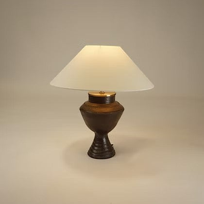 Lampe de table Maison Olive en céramique sombre texturée avec abat-jour en tissu clair et détails en laiton doré.
