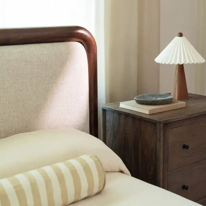 Lit Maison Olive avec tête de lit rembourrée beige et cadre en bois massif sombre dans une chambre élégante