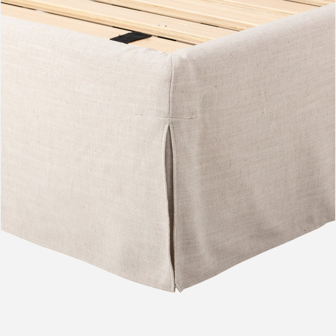 Lit Maison Olive capitonné crème avec jupe et tête de lit arquée, revêtement en tissu texturé.