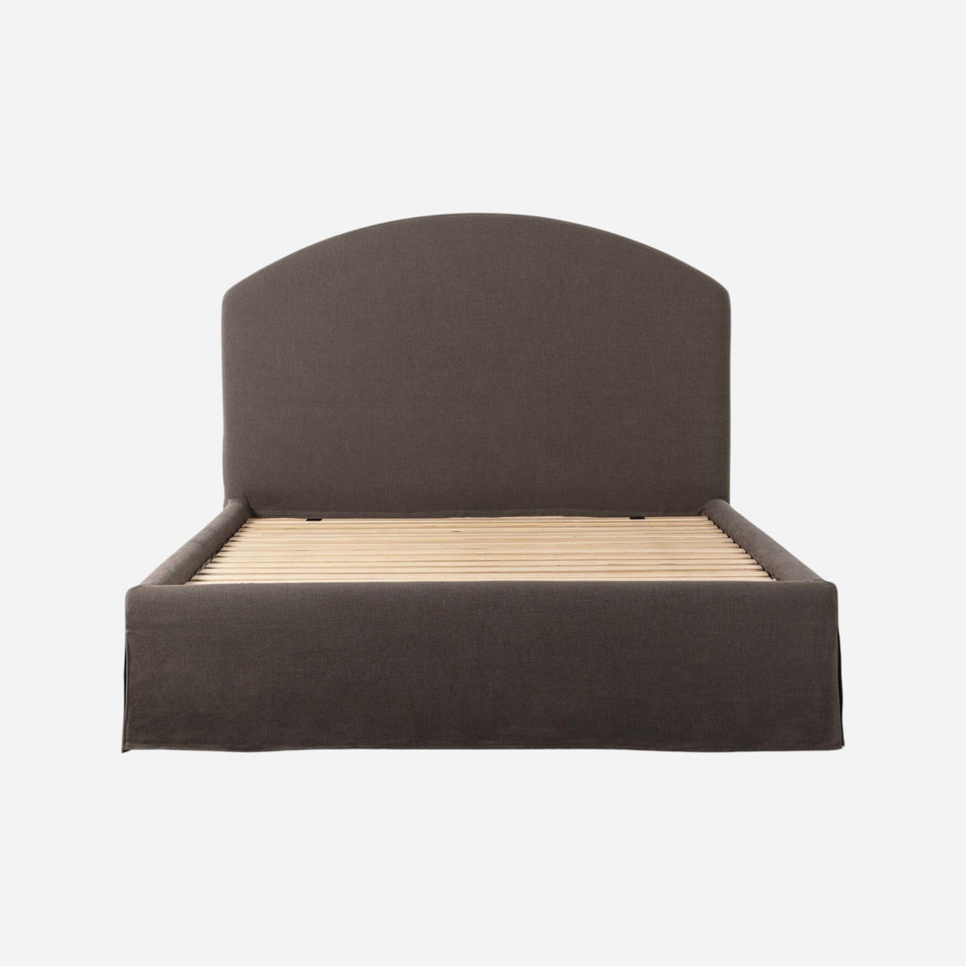Lit capitonné Maison Olive avec jupe et tête de lit arquée en tissu texturé gris foncé, sommier à lattes inclus.