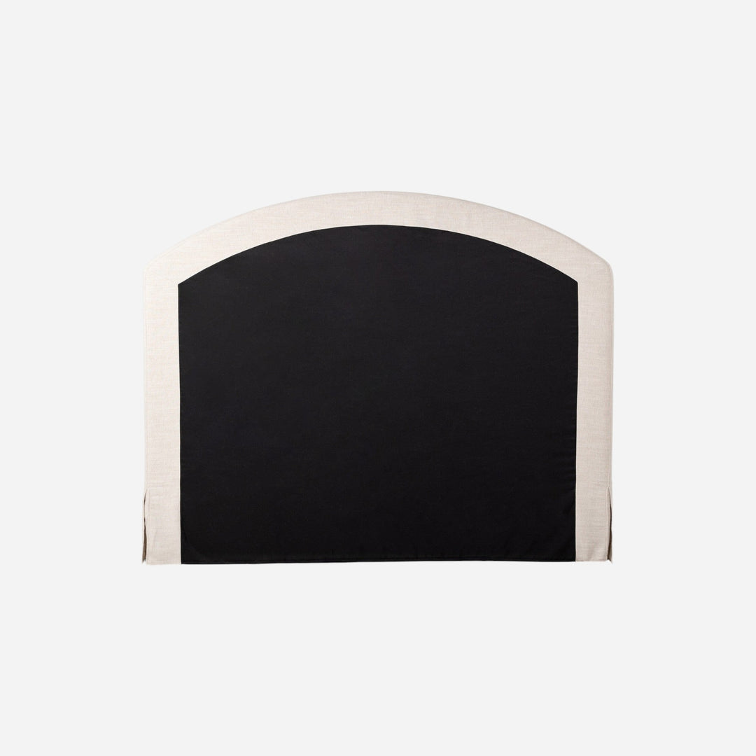 Lit capitonné Maison Olive avec jupe et tête de lit arquée en tissu texturé crème et noir.