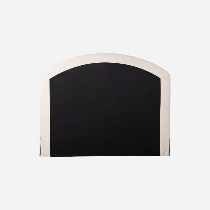 Lit capitonné Maison Olive avec jupe et tête de lit arquée en tissu texturé crème et noir.