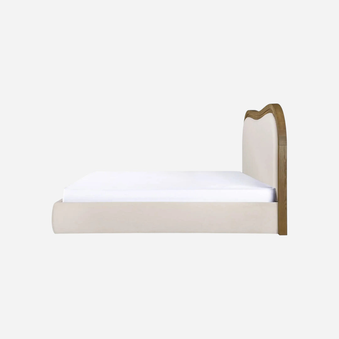 Lit EMMA Maison Olive avec tête de lit ondulée en polyester beige et structure en bois de frêne brun, vue de profil.