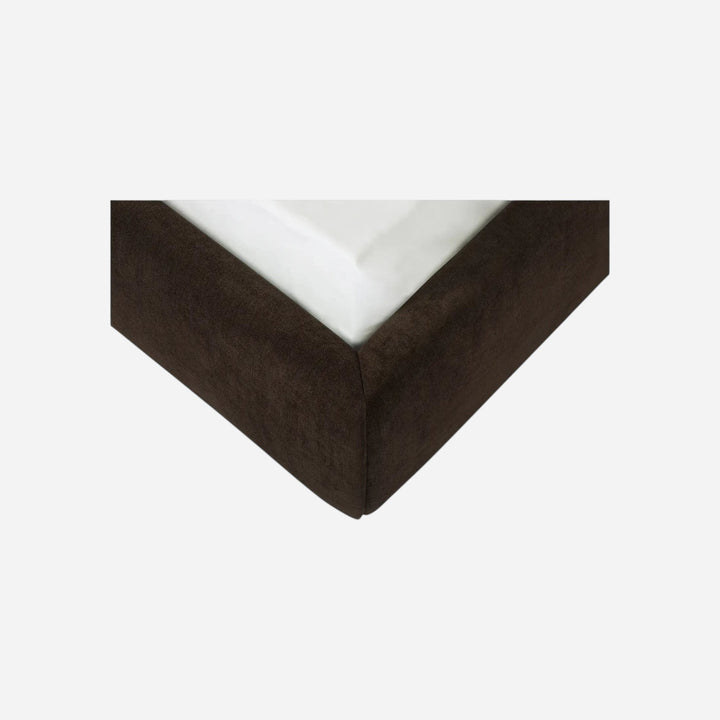 Gros plan sur le coin du lit Maison Olive EMMA avec revêtement en polyester brun et matelas blanc