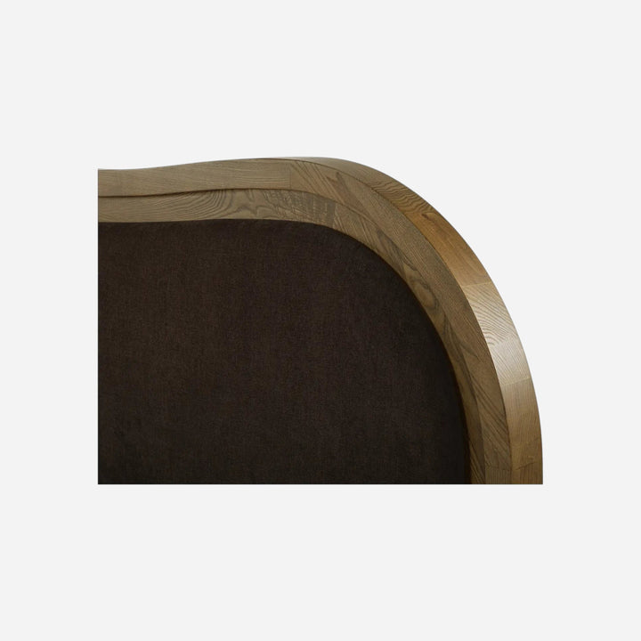 Gros plan sur la tête de lit Maison Olive EMMA en bois de frêne brun et tissu rembourré aux courbes Art déco