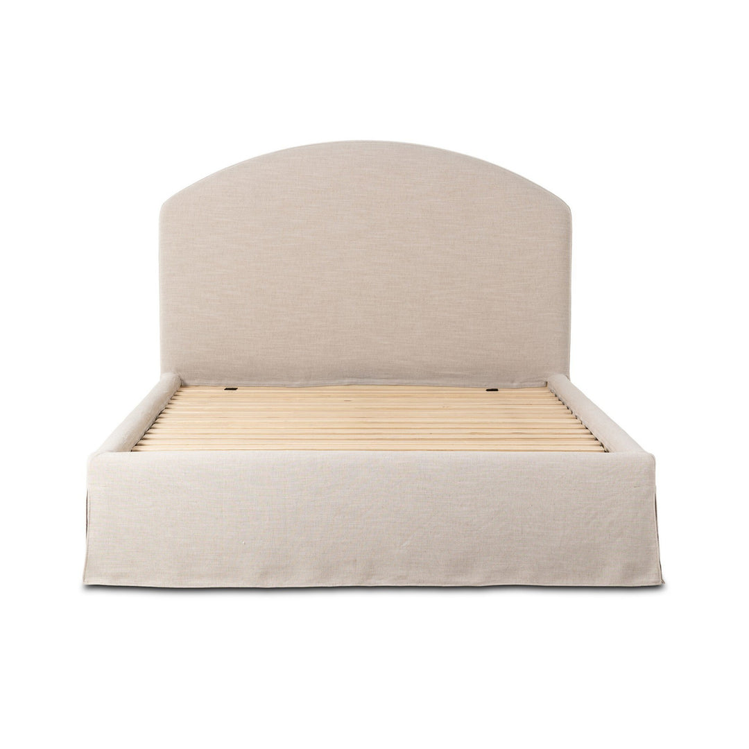 Lit Maison Olive capitonné crème avec jupe et tête de lit arquée, revêtement en tissu texturé, sommier à lattes inclus.