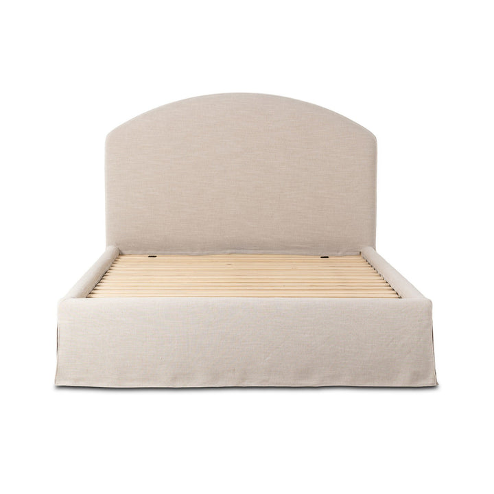 Lit Maison Olive capitonné crème avec jupe et tête de lit arquée, revêtement en tissu texturé, sommier à lattes inclus.