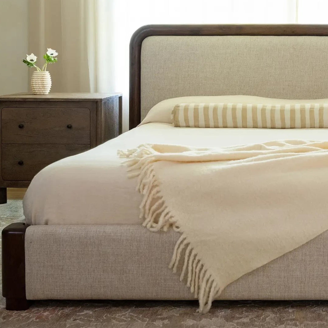 Lit Maison Olive rembourré en tissu beige avec cadre en bois massif sombre et tête de lit élégante dans une chambre