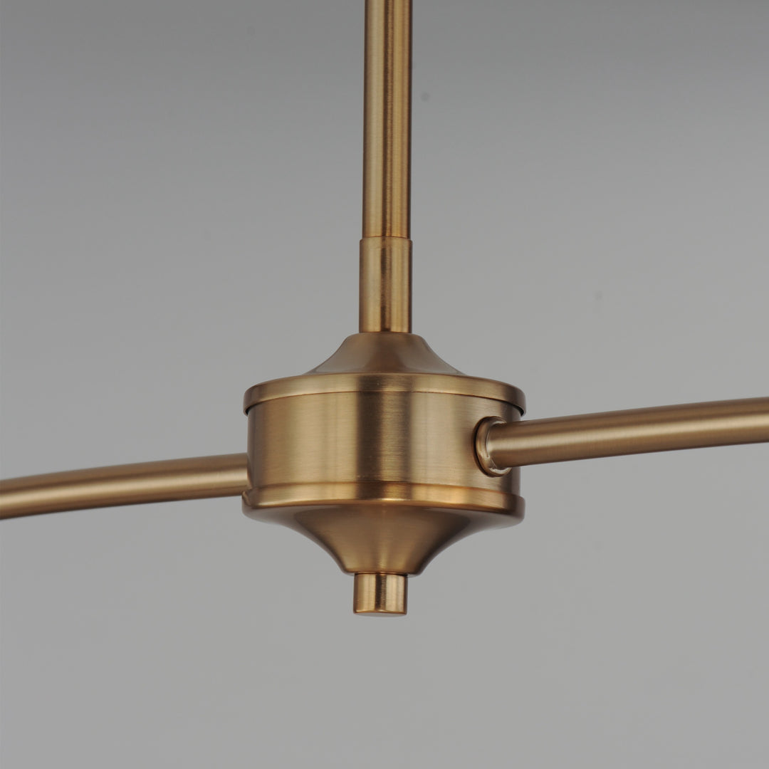 Détail du luminaire Maison Olive en métal brossé doré avec structure centrale élégante et bras horizontaux