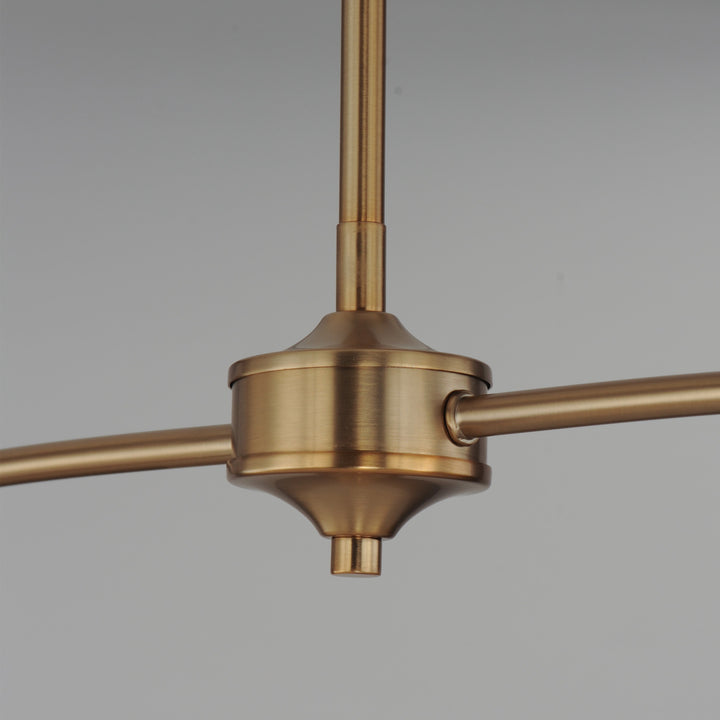 Détail du luminaire Maison Olive en métal brossé doré avec structure centrale élégante et bras horizontaux