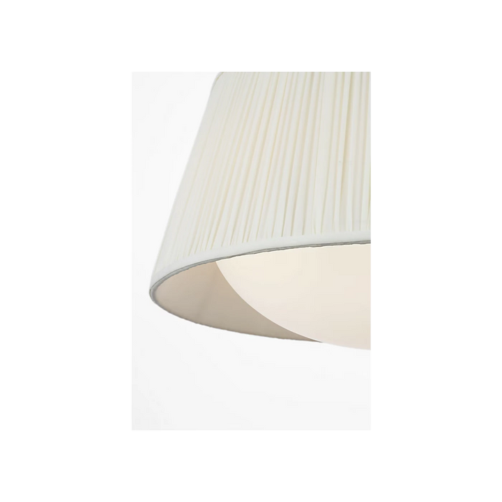 Maison Olive lustre abat-jour plissé crème avec structure argentée, lumière douce et chaleureuse.