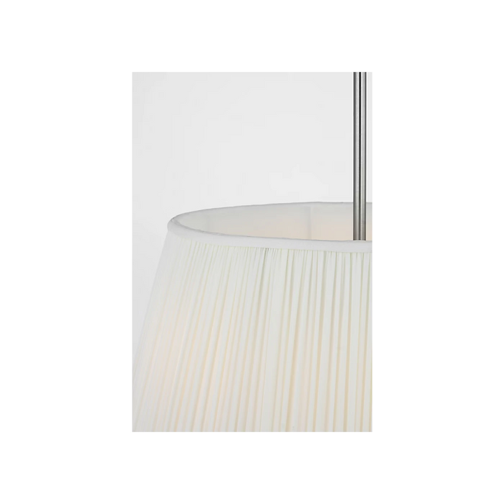 Maison Olive lustre abat-jour plissé crème avec structure métal argenté brossé, lumière douce.
