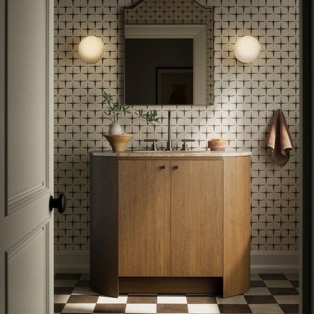 Maison Olive meuble de salle de bain en bois de chêne avec lavabo intégré en pierre beige et robinetterie bronze.