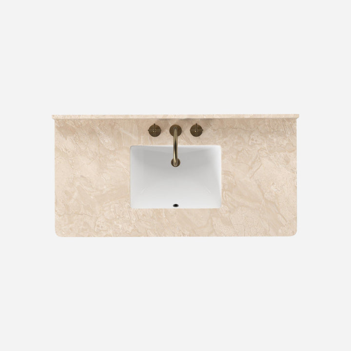 Maison Olive Meuble de salle de bain suspendu en bois de chêne avec plateau en marbre crème, vasque blanche et robinetterie dorée.