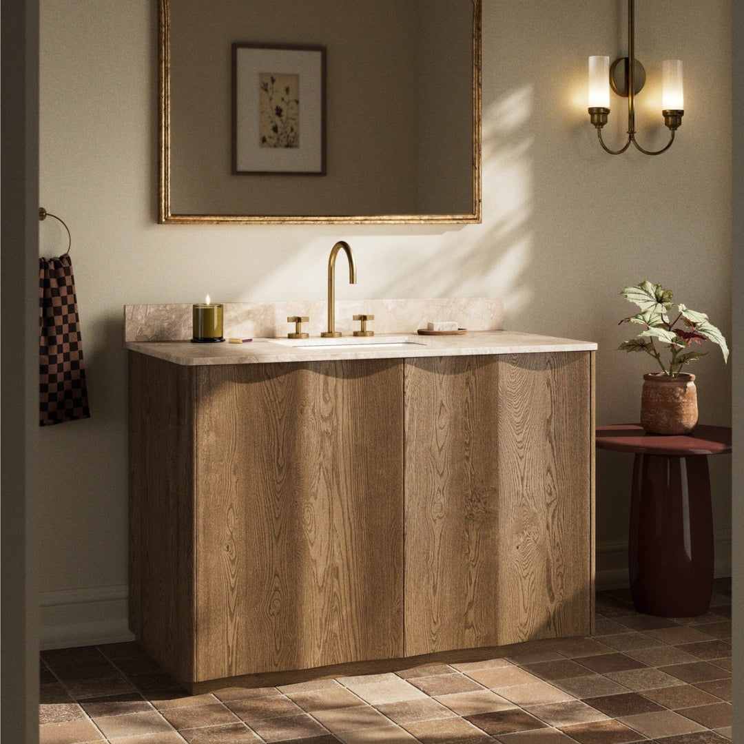 Maison Olive meuble de salle de bain en bois de chêne avec plateau en marbre crème et vasque blanche. Robinetterie dorée.