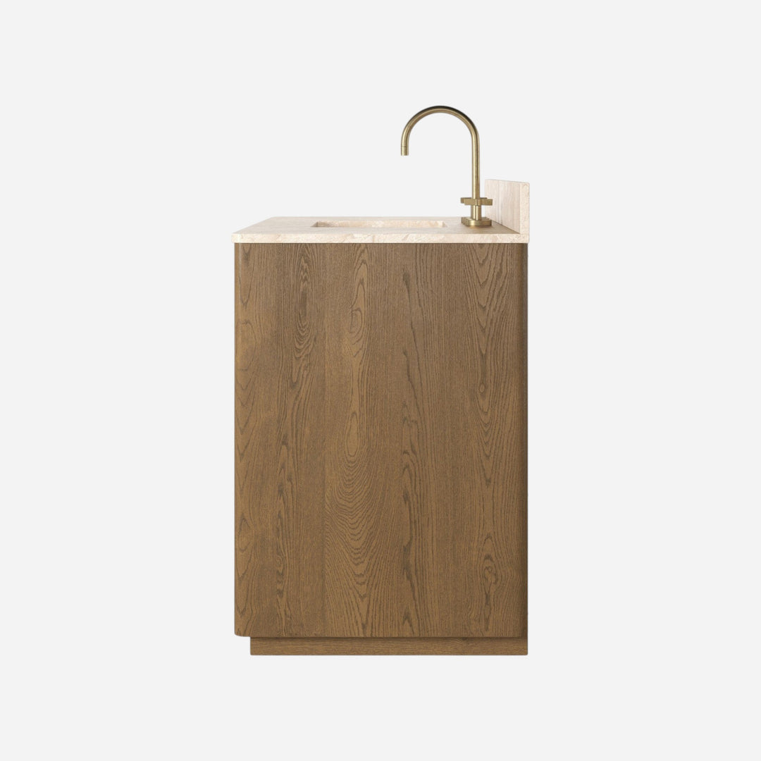 Maison Olive meuble de salle de bain suspendu en bois de chêne avec plateau en marbre crème et robinetterie dorée.