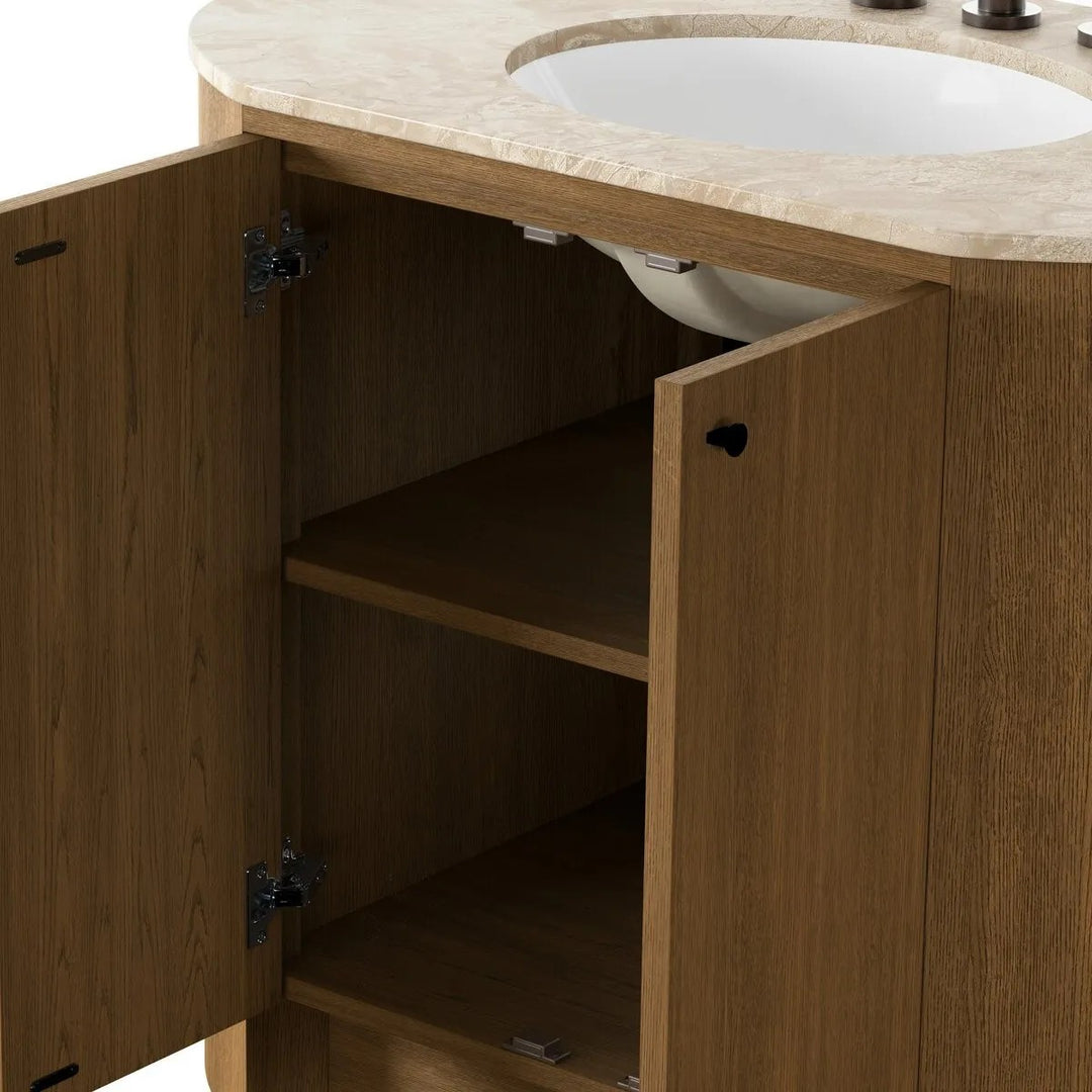 Meuble vasque Maison Olive en bois de chêne naturel avec plateau en pierre beige et vasque intégrée. Portes arrondies avec poignées bronze.