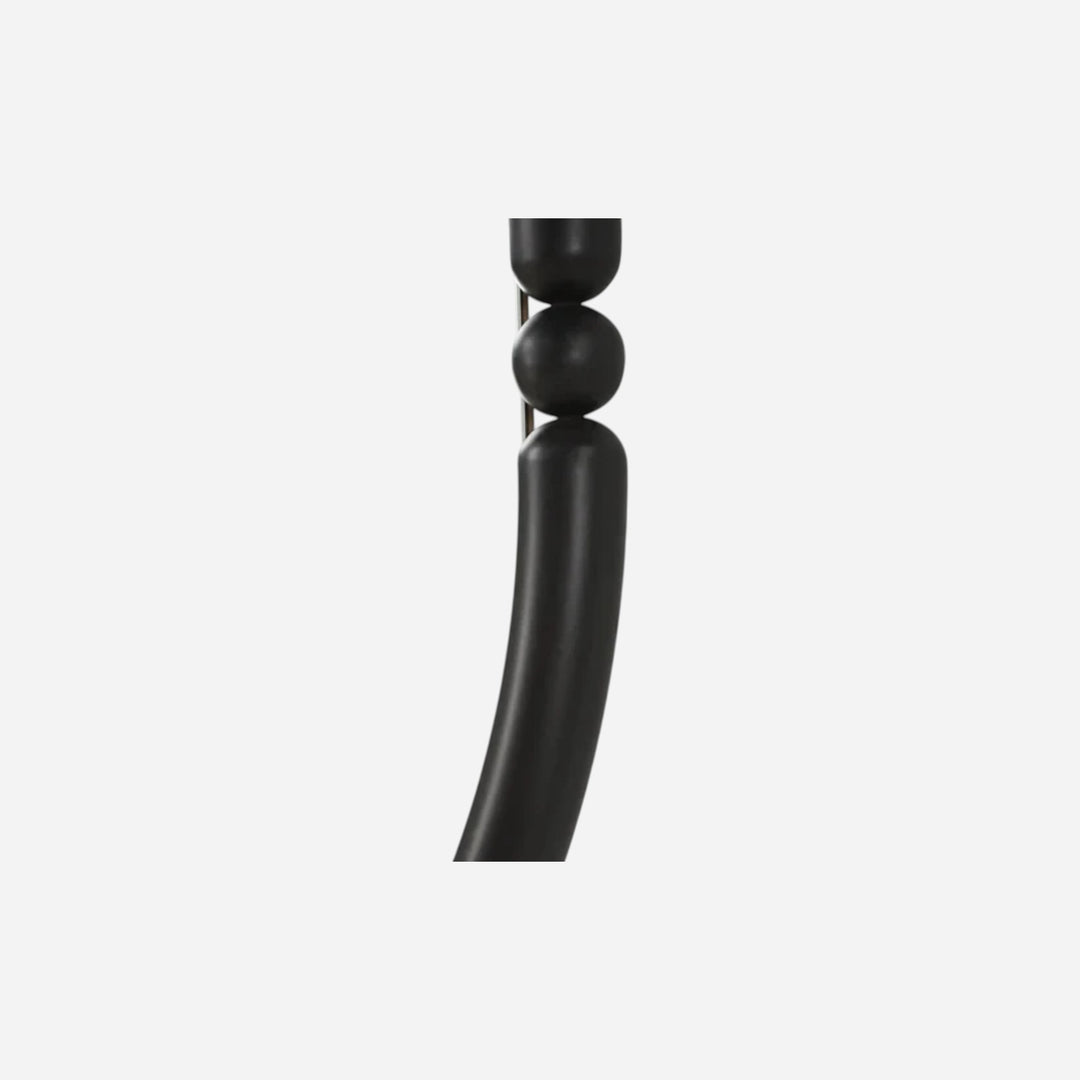 Gros plan sur le cadre en fer thermolaqué noir mat du miroir ovale Maison Olive avec détails de perles sculpturales.